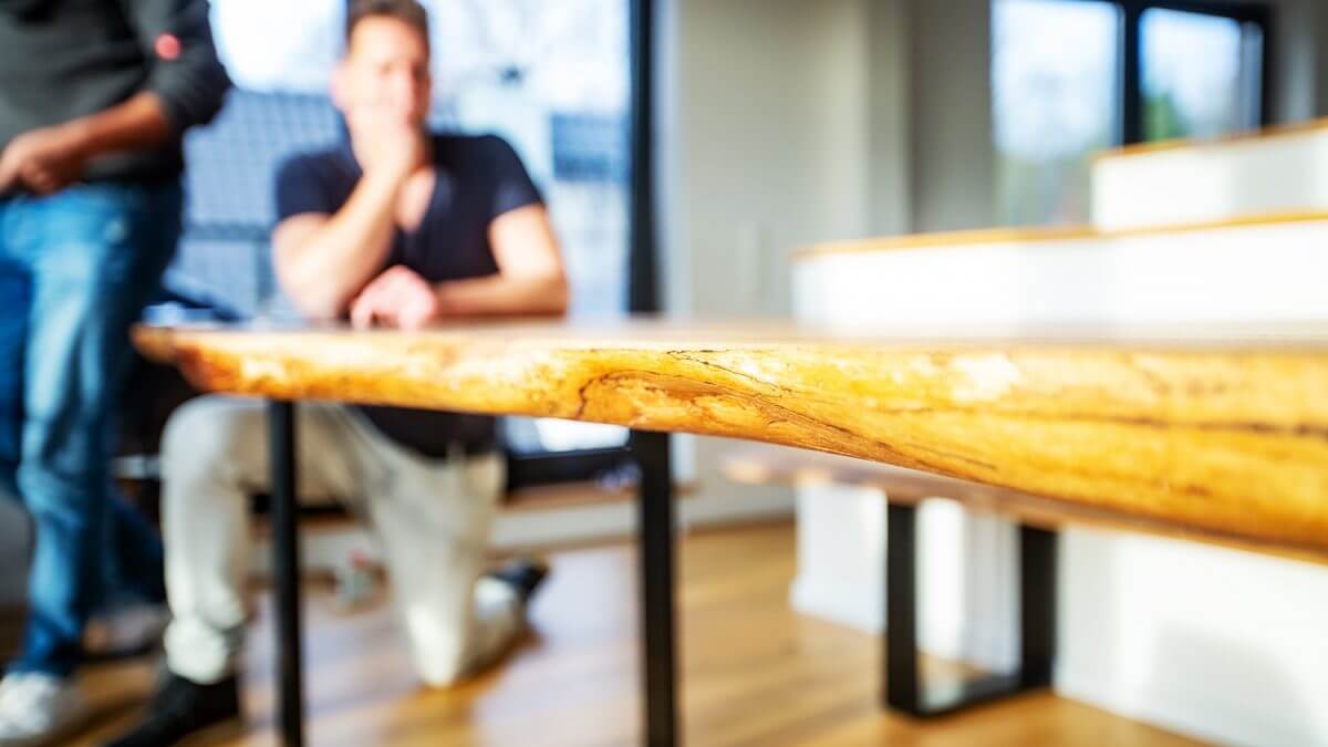 BRETTArt-Team bei der Handarbeit am Massivholz-Tisch in der Werkstatt