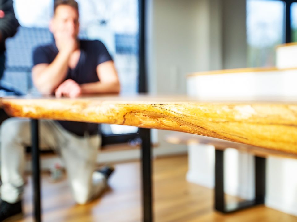 BRETTArt-Team bei der Handarbeit am Massivholz-Tisch in der Werkstatt